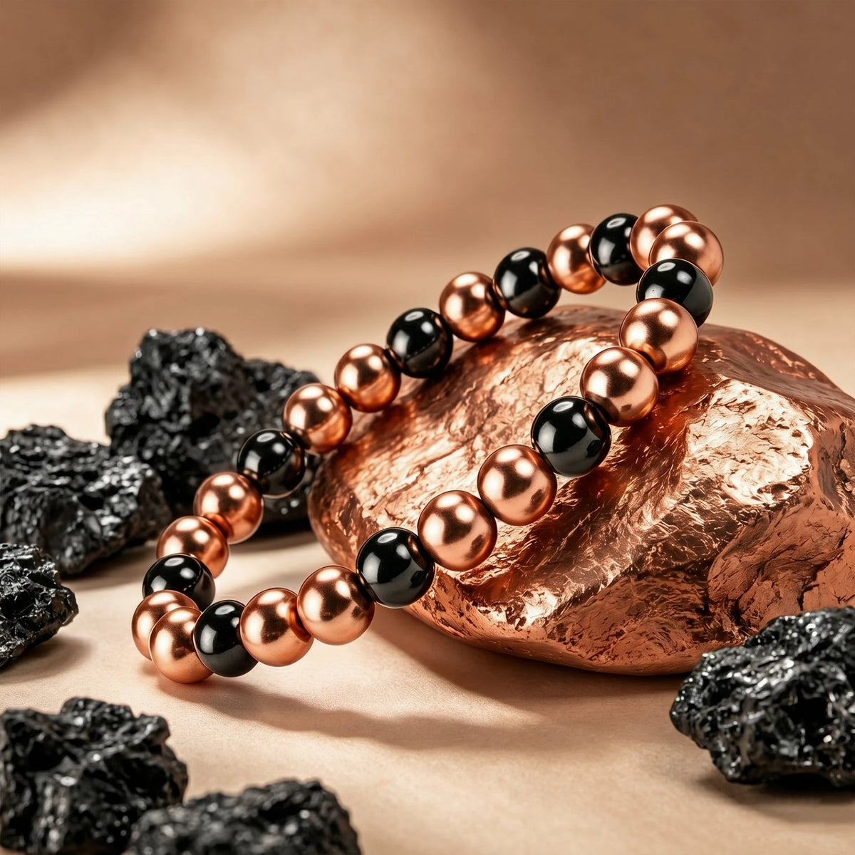 Magnetic copper beaded bracelet resting on raw copper nugget and black volcanic lava rocks