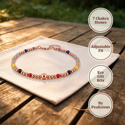 Copper bead anklet on white linen cloth with circular labels reading 7 Chakra Stones, Adjustable Fit, Eco Gift Box and By Pealicious