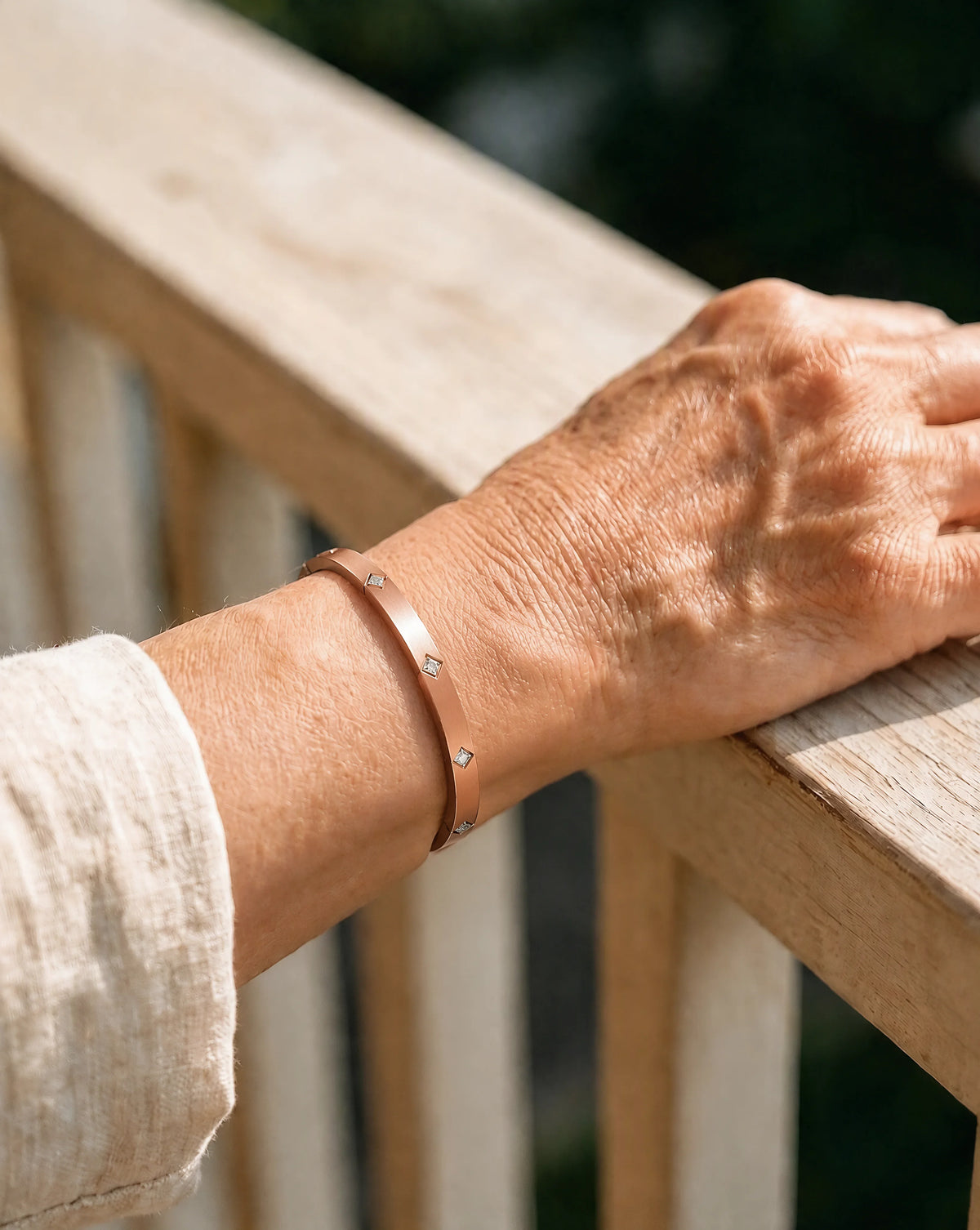 Woman wearing the adjustable solid copper crystal cuff bracelet outdoors on wooden railing