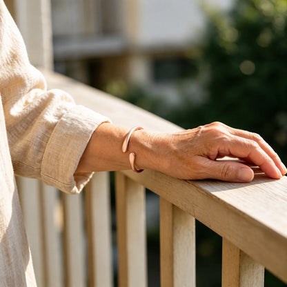 Woman wearing pure copper teardrop cuff bracelet on wrist outdoors