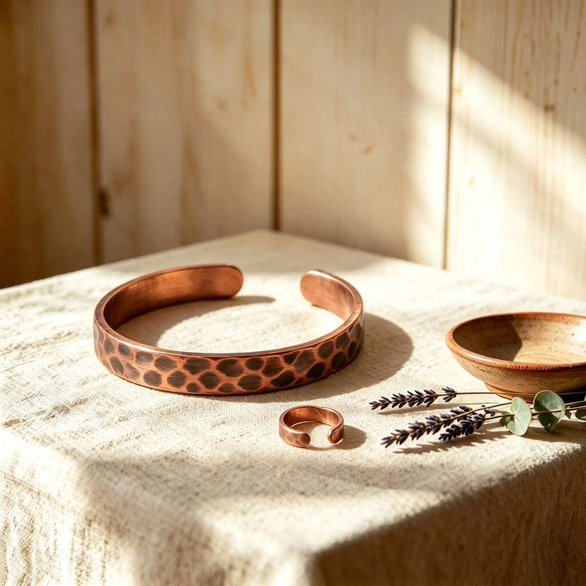 Hammered solid copper cuff bracelet and matching ring set with leopard texture on linen table