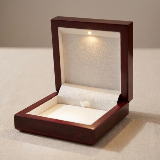Luxury mahogany wooden jewelry gift box opened with built-in LED light spotlight and white cushioned interior
