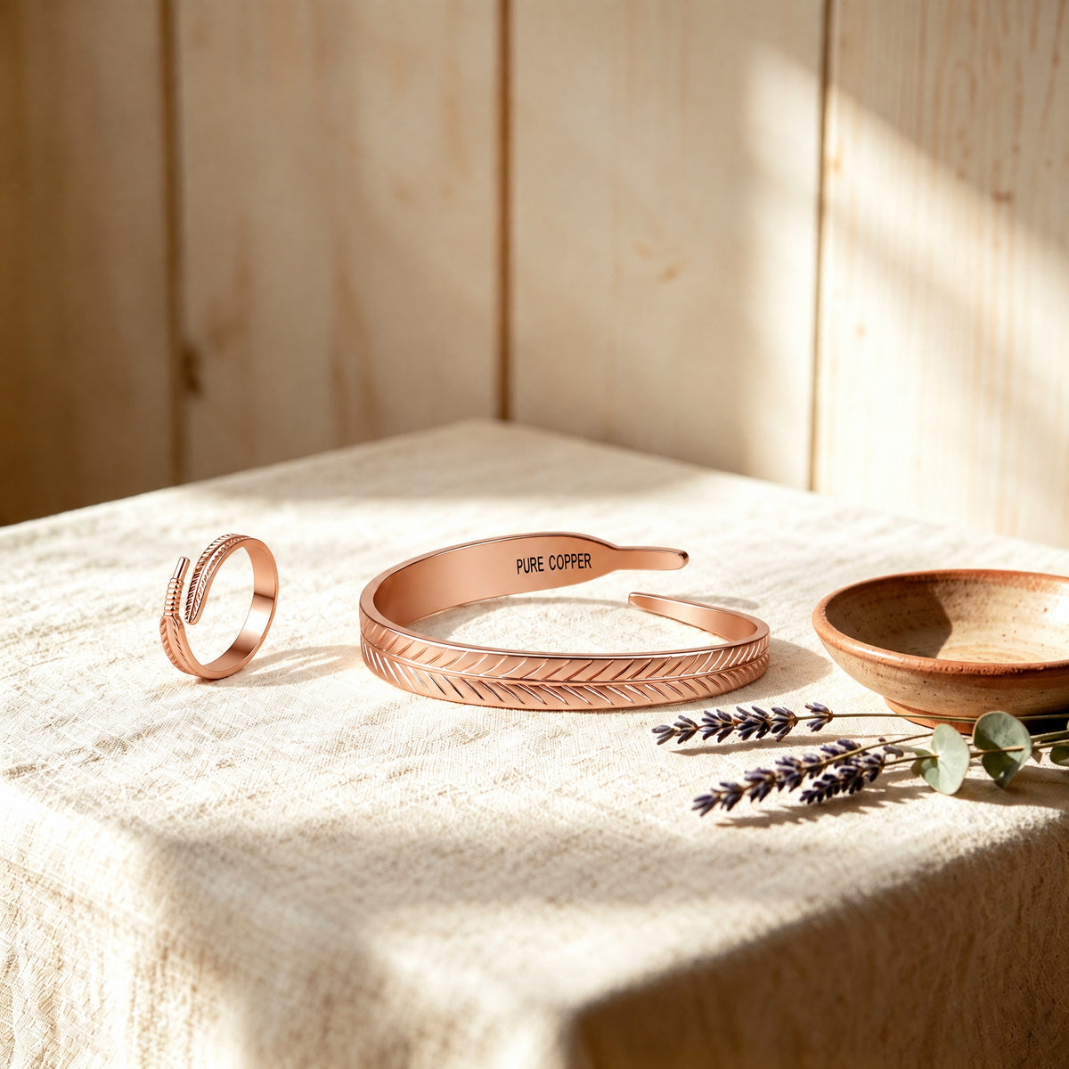 Solid copper feather leaf cuff bracelet and matching open ring set engraved with pure copper on linen table
